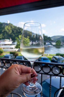 Mosel şarap bölgesinde açık havada servis edilen beyaz kaliteli şarap kadehiyle el ele tutuştuk. Mosel nehri ve eski Alman kasabası güneşli bir günde, Almanya 'da arka planda yer aldı.