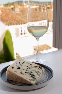 Peynir koleksiyonu, Roquefort-sur-Soulzon, Fransa 'dan yarı sert Fransız rokfor peyniri, soğuk beyaz Fransız şarabı ile servis edilir, yakın çekim.