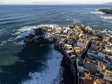 Puerto de la Cruz, Tenerife, Kanarya Adaları yakınlarındaki küçük balıkçı köyünde renkli evlerin ve siyah lav kayalarının hava manzarası.