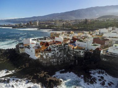 Puerto de la Cruz, Tenerife, Kanarya Adaları yakınlarındaki küçük balıkçı köyünde renkli evlere ve siyah lav kayalarına hava manzarası