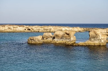 Kıbrıs Rum Kesimi 'nin Protaras yakınlarındaki Turtle Körfezi' nde Akdeniz 'in berrak mavi suyu ve sarı kayalar