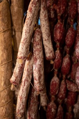 Parma, Emilia Romagna, İtalya 'daki kasapta asılı duran ev yapımı kurutulmuş salam sosisleri, et yemekleri arka planı.