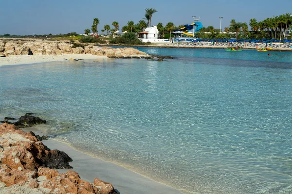 Kıbrıs Rum Kesimi 'nin Ayia Napa kentindeki beyaz kumlu Nissi plajında Akdeniz' in berrak mavi suyu