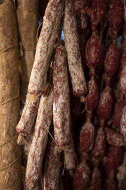 Parma, Emilia Romagna, İtalya 'daki kasapta asılı duran ev yapımı kurutulmuş salam sosisleri, et yemekleri arka planı.