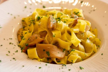 İtalyan yemeği, balık yemeği, ev yapımı taze makarna, porcini mantarlı tagliatelle, Parma, Emilia Romagna, İtalya, kapatın.