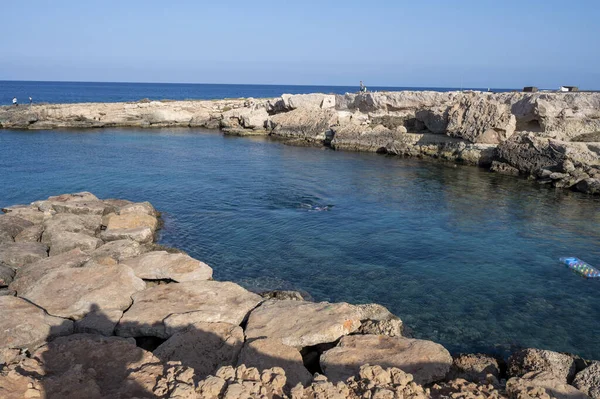 Crystal clear sea water in small rocky bay near Fig tree beach in Protaras, Cyprus in sunny day