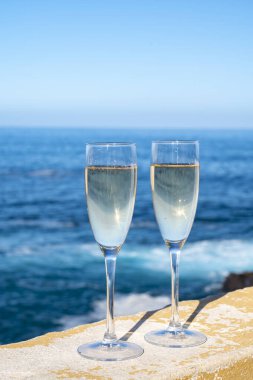 Yeni yıl kutlamalarında iki kadeh şampanya ya da İspanyol kavası köpüklü şarap ve Atlantik 'in mavi suları, Kanarya adaları, kış turistleri