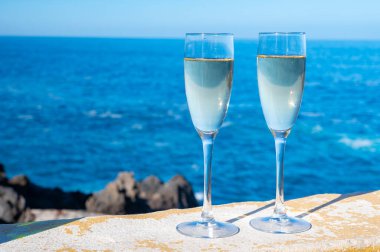 Yeni yıl kutlamalarında iki kadeh şampanya ya da İspanyol kavası köpüklü şarap ve Atlantik 'in mavi suları, Kanarya adaları, kış turistleri