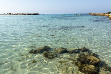 Kıbrıs Rum Kesimi 'nin Ayia Napa kentindeki beyaz kumlu Nissi plajında Akdeniz' in berrak mavi suyu