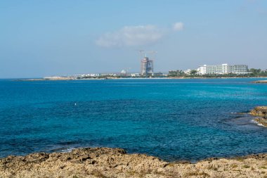 Kıbrıs Rum Kesimi 'nin Ayia Napa kentindeki beyaz kumlu Nissi plajında Akdeniz' in berrak mavi suyu