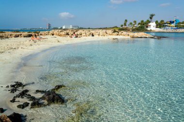 Kıbrıs Rum Kesimi 'nin Ayia Napa kentindeki beyaz kumlu Nissi plajında Akdeniz' in berrak mavi suyu