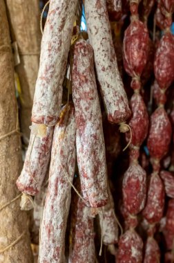 Parma, Emilia Romagna, İtalya 'daki kasapta asılı duran ev yapımı kurutulmuş salam sosisleri, et yemekleri arka planı.
