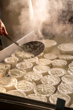 İtalya 'nın Parma kentindeki küçük peynir çiftliğinde sabahın erken saatlerinde taze, yumuşak ricotta peyniri yapma süreci.