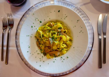 İtalyan yemeği, balık yemeği, ev yapımı taze makarna, porcini mantarlı tagliatelle, Parma, Emilia Romagna, İtalya, kapatın.