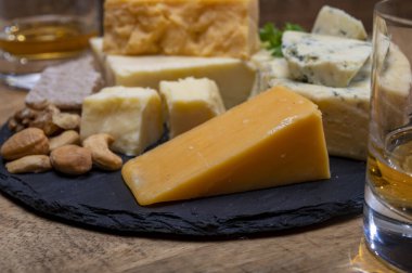 İngiliz içecekleri ve yiyecek eşleşmesi, bir bardak viski ve peynir koleksiyonu, mavi Stilton, İskoç renkli ve İngiliz olgun çedar peyniri