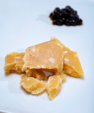 Parma 'dan 72 aylık İtalyan parmegiano-reggiano parmesan peyniri tadı son derece tahıllı ve parçalanmış bir yapısı ve siyah balzamik sirke incileri ile yoğun bir tadı var. Modena' dan DOP, yakın plan.