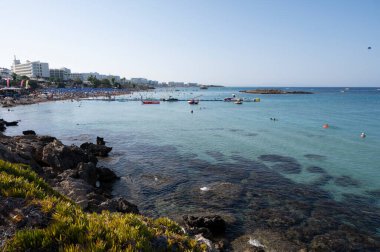 Kıbrıs Rum Kesimi 'nin Protaras kentindeki beyaz kumlu incir ağacı plajında Akdeniz' in berrak mavi suyu