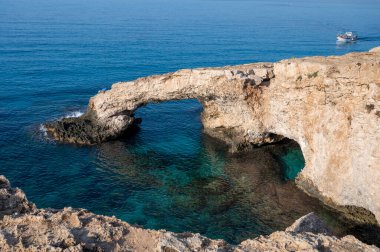 Kıbrıs Rum Kesimi 'nde turistler, doğal Aşk Köprüsü ve Akdeniz' in turkuaz suyu üzerinde sabahleyin
