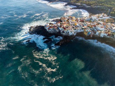 Puerto de la Cruz, Tenerife, Kanarya Adaları yakınlarındaki küçük balıkçı köyünde renkli evlerin ve siyah lav kayalarının hava manzarası.