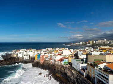 Puerto de la Cruz, Tenerife yakınlarındaki Punta Brava adlı küçük balıkçı köyünde renkli evler ve siyah lav kayaları üzerindeki hava manzarası, kışın İspanya 'da Kanarya Adaları
