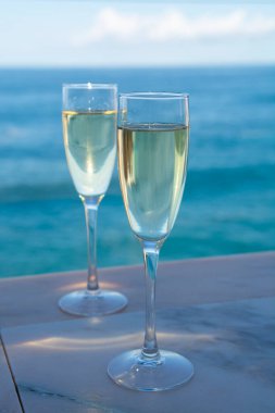 Yeni yıl kutlamalarında iki kadeh şampanya ya da İspanyol kavası köpüklü şarap ve Atlantik 'in mavi suları, Kanarya adaları, kış turistleri