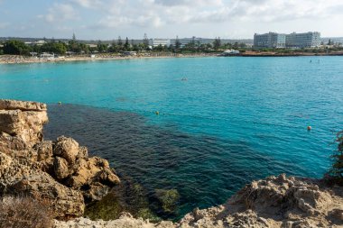 Kıbrıs Rum Kesimi 'nin Ayia Napa kentindeki beyaz kumlu Nissi plajında Akdeniz' in berrak mavi suyu
