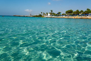 Kıbrıs Rum Kesimi 'nin Ayia Napa kentindeki beyaz kumlu Nissi plajında Akdeniz' in berrak mavi suyu