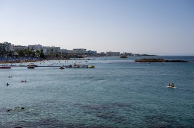 Kıbrıs Rum Kesimi 'nin Protaras kentindeki beyaz kumlu incir ağacı plajında Akdeniz' in berrak mavi suyu