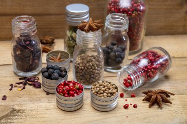 Küçük şişelerdeki profesyonel cin baharatları, pembe biber, amber çiçekleri, ardıç meyveleri, kakule, kişniş tohumları, yıldız anason yakın çekim