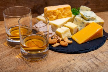 İngiliz içecekleri ve yiyecek eşleşmesi, bir bardak viski ve peynir koleksiyonu, mavi Stilton, İskoç renkli ve İngiliz olgun çedar peyniri