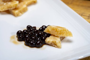 Parma 'dan 72 aylık İtalyan parmegiano-reggiano parmesan peyniri tadı son derece tahıllı ve parçalanmış bir yapısı ve siyah balzamik sirke incileri ile yoğun bir tadı var. Modena' dan DOP, yakın plan.