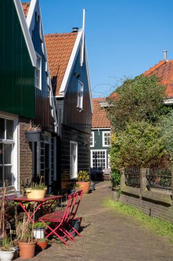 Hollanda 'nın küçük Marken kasabasında güneşli bir bahar gününde eski Hollanda, Hollanda' da bulunan ahşap evlerle yürüyorum.