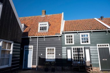 Hollanda 'nın küçük Marken kasabasında güneşli bir bahar gününde eski Hollanda, Hollanda' da bulunan ahşap evlerle yürüyorum.
