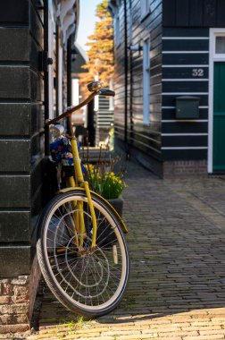 Hollanda 'nın küçük Marken kasabasında güneşli bir bahar gününde eski Hollanda, Hollanda' da bulunan ahşap evlerle yürüyorum.