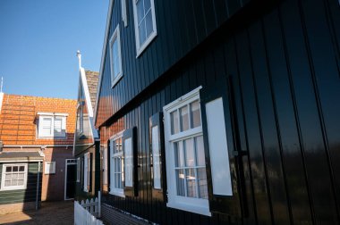 Hollanda 'nın küçük Marken kasabasında güneşli bir bahar gününde eski Hollanda, Hollanda' da bulunan ahşap evlerle yürüyorum.
