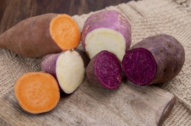 Renkli kök sebzeler pembe, mor ve turuncu organik tatlı patatesler yakın çekim