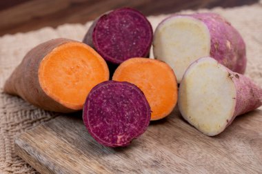 Renkli kök sebzeler pembe, mor ve turuncu organik tatlı patatesler yakın çekim