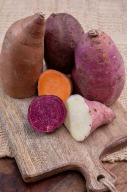 Renkli kök sebzeler pembe, mor ve turuncu organik tatlı patatesler yakın çekim