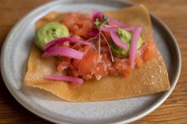 Meksika yemeği, kızarmış mısır tortilla füme somon, guacamole sosu ve pembe soğan turşusu.