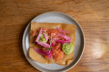 Meksika yemeği, kızarmış mısır tortilla füme somon, guacamole sosu ve pembe soğan turşusu.