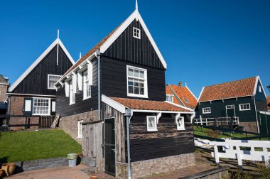 Hollanda 'nın küçük Marken kasabasında güneşli bir bahar gününde eski Hollanda, Hollanda' da bulunan ahşap evlerle yürüyorum.