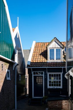 Hollanda 'nın küçük Marken kasabasında güneşli bir bahar gününde eski Hollanda, Hollanda' da bulunan ahşap evlerle yürüyorum.
