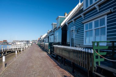 Hollanda 'nın küçük Marken kasabasında güneşli bir bahar gününde eski Hollanda, Hollanda' da bulunan ahşap evlerle yürüyorum.