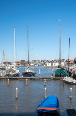 Hollanda 'nın küçük Marken kasabasında güneşli bir bahar gününde eski Hollanda, Hollanda' da bulunan ahşap evlerle yürüyorum.