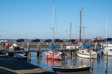 Hollanda 'nın küçük Marken kasabasında güneşli bir bahar gününde eski Hollanda, Hollanda' da bulunan ahşap evlerle yürüyorum.