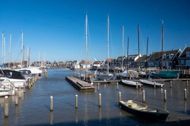 Hollanda 'nın küçük Marken kasabasında güneşli bir bahar gününde eski Hollanda, Hollanda' da bulunan ahşap evlerle yürüyorum.
