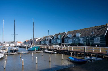 Hollanda 'nın küçük Marken kasabasında güneşli bir bahar gününde eski Hollanda, Hollanda' da bulunan ahşap evlerle yürüyorum.