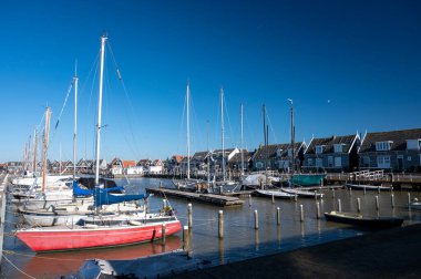Hollanda 'nın küçük Marken kasabasında güneşli bir bahar gününde eski Hollanda, Hollanda' da bulunan ahşap evlerle yürüyorum.