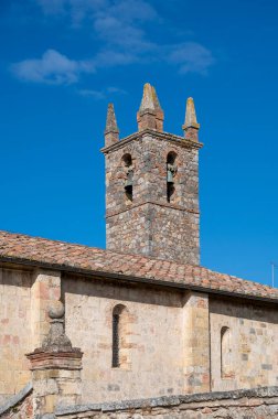 İtalya 'nın Toskana kentindeki Monteriggione tepesindeki ortaçağ kale kasabasındaki eski kasaba duvarlarının içindeki evler.