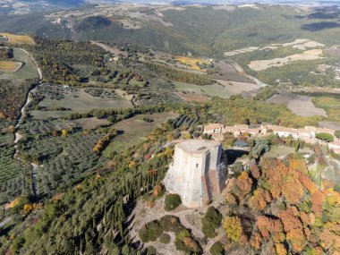 İtalya 'nın Toskana kentindeki tepelerde sonbaharda ortaçağ kalesi ve manzarası